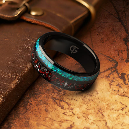 Black domed tungsten ring with red and silver-gray fragments beside a blue-green opal inlay.