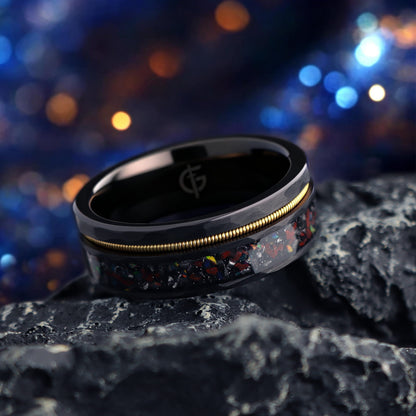 Hammered black tungsten carbide ring with a gold-tone guitar string and red-brown, silver-gray and multicolor inlays