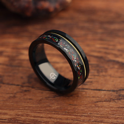 Hammered black tungsten carbide ring with a gold-tone guitar string and red-brown, silver-gray and multicolor inlays