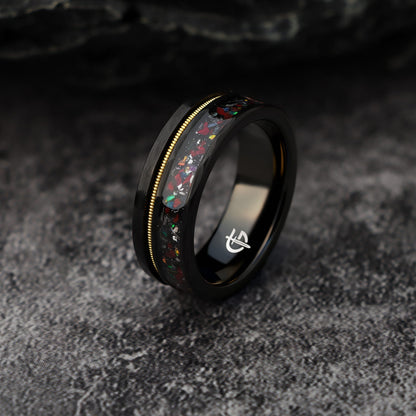 Hammered black tungsten carbide ring with a gold-tone guitar string and red-brown, silver-gray and multicolor inlays
