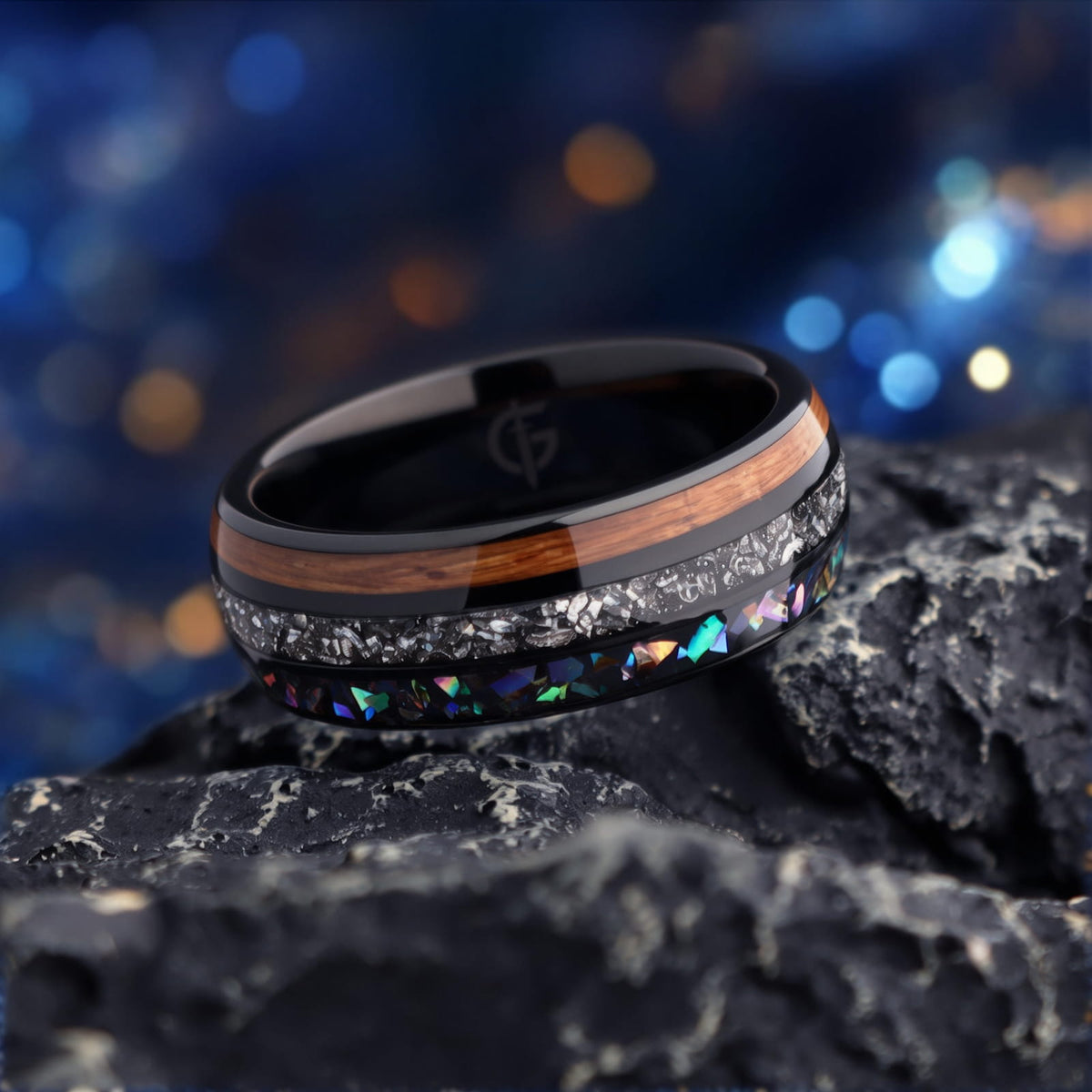 Black domed ring with brown wood, silver-gray meteorite, and iridescent abalone in three separate channels.