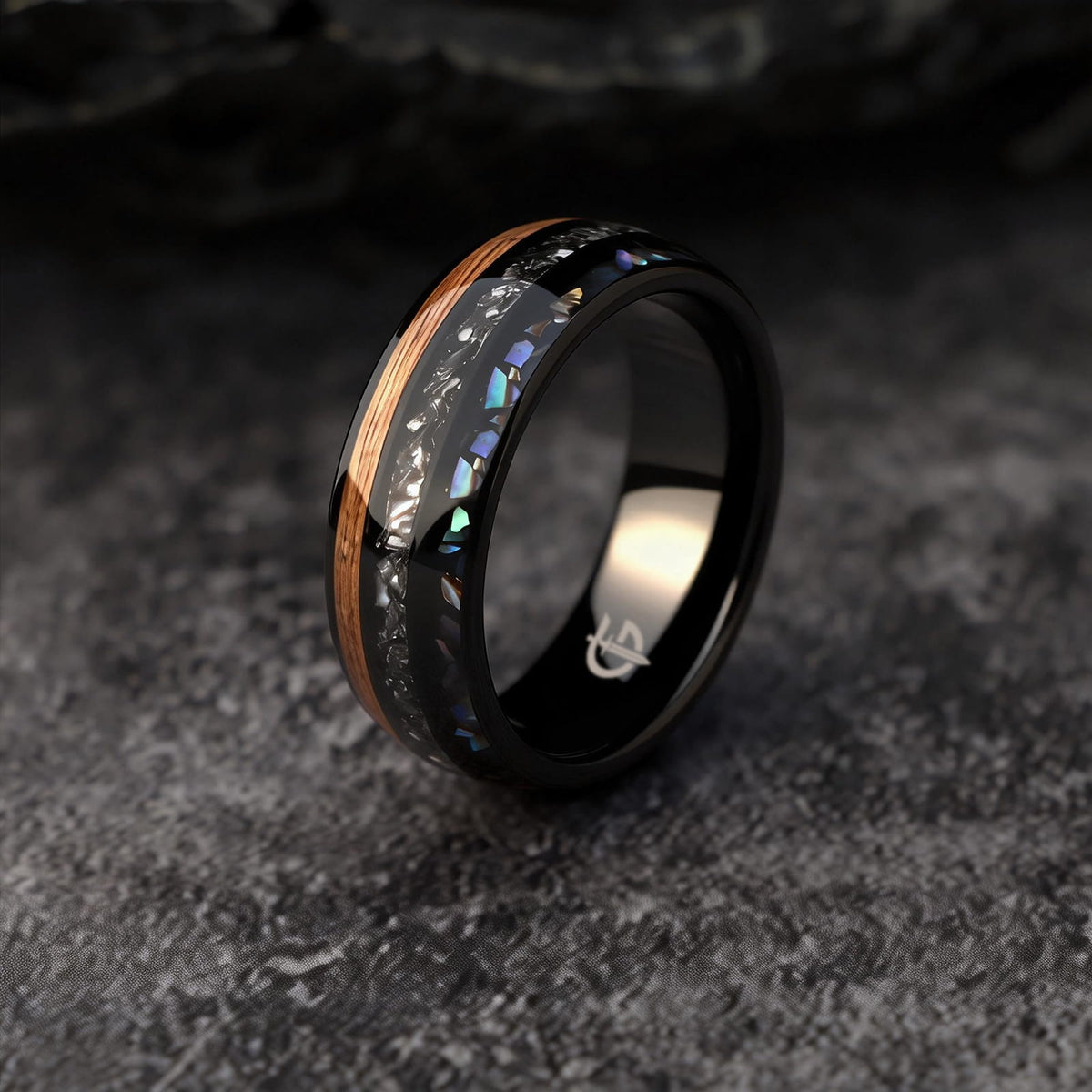 Black domed ring with brown wood, silver-gray meteorite, and iridescent abalone in three separate channels.