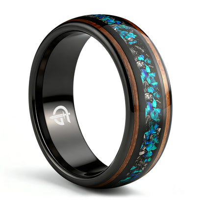 Black domed ring with two wood strips framing a center inlay of silver-gray and blue-green fragments.