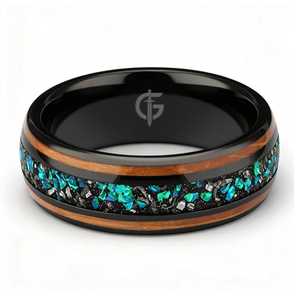 Black domed ring with two wood strips framing a center inlay of silver-gray and blue-green fragments.