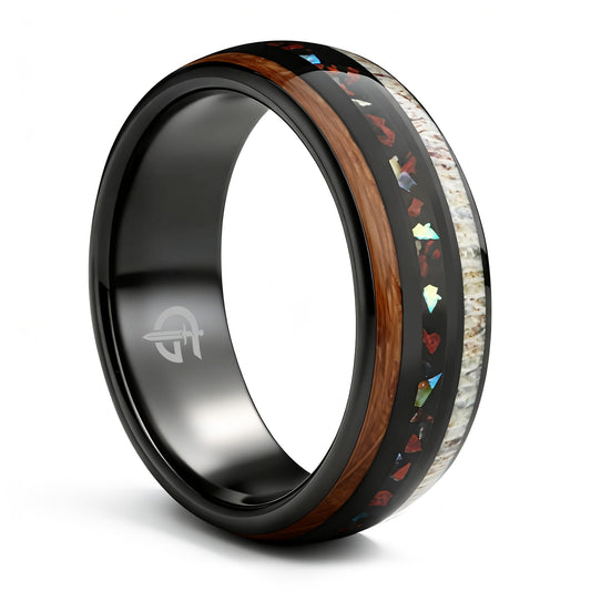 Black tungsten ring with wood and pale antler framing red dinosaur bone and iridescent abalone shell