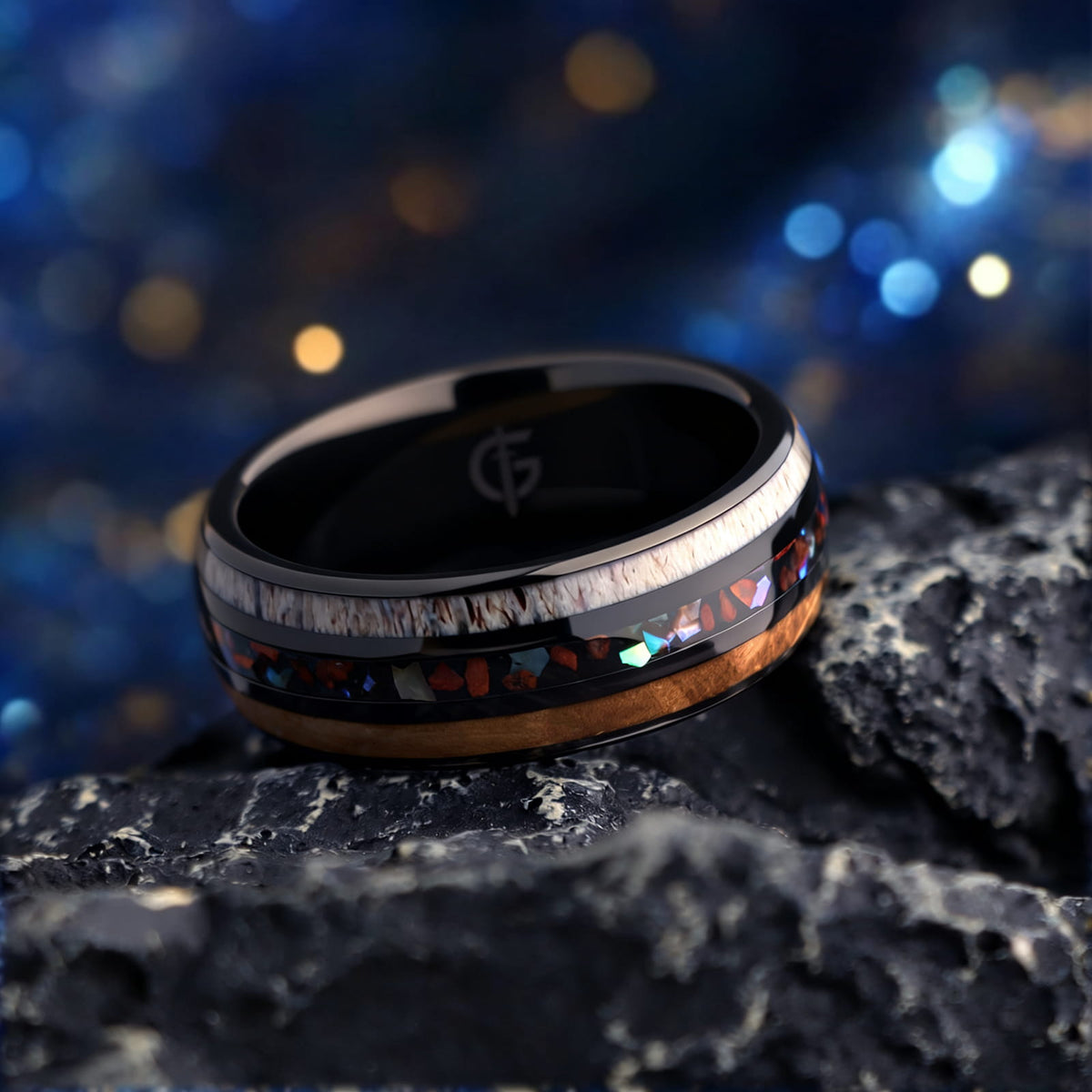 Black tungsten ring with wood and pale antler framing red dinosaur bone and iridescent abalone shell