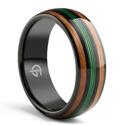 Polished black tungsten ring with green fishing line between two brown whiskey barrel wood bands
