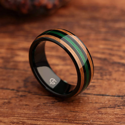Polished black tungsten ring with green fishing line between two brown whiskey barrel wood bands