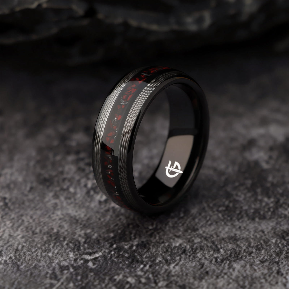 Black tungsten ring with silver-tone fishing line flanking a red dinosaur bone and silver-gray meteorite center