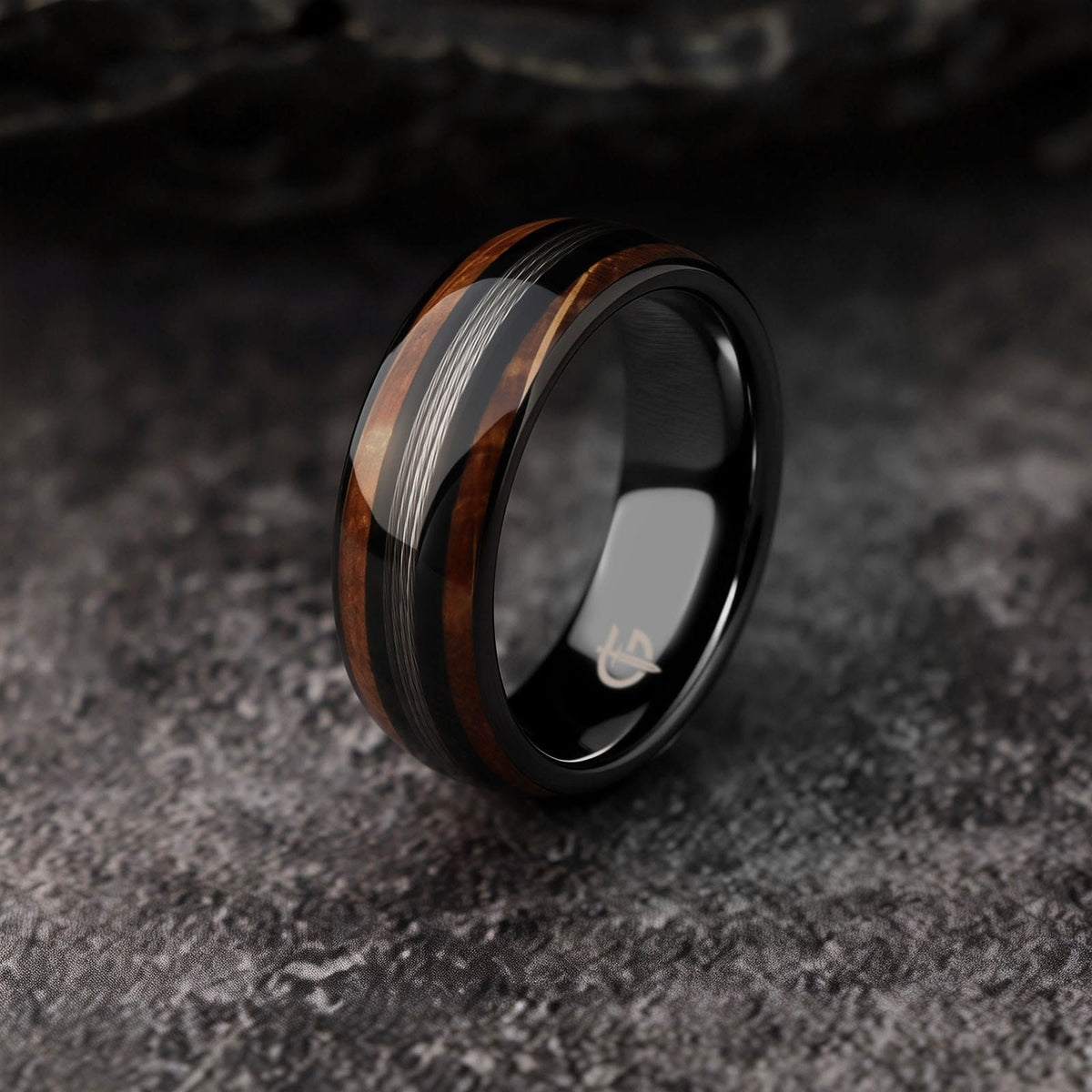 Black tungsten ring with silver-tone fishing line centered between two whiskey barrel wood bands